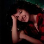 Smiling woman with curly hair in a plaid shirt portrait