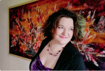 Woman smiling in front of vibrant abstract painting art