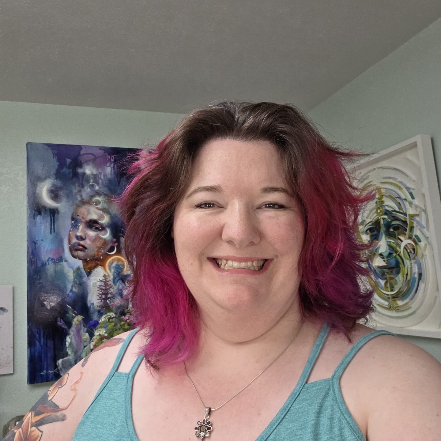 Smiling woman with vibrant pink hair in a casual setting
