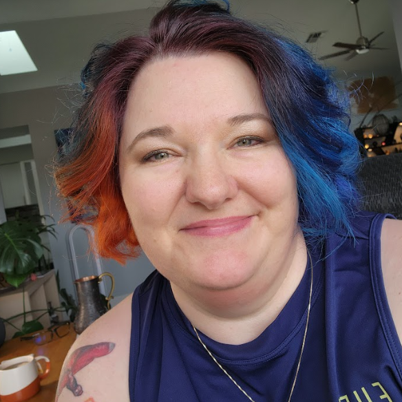 Smiling woman with colorful hair in a cozy indoor setting